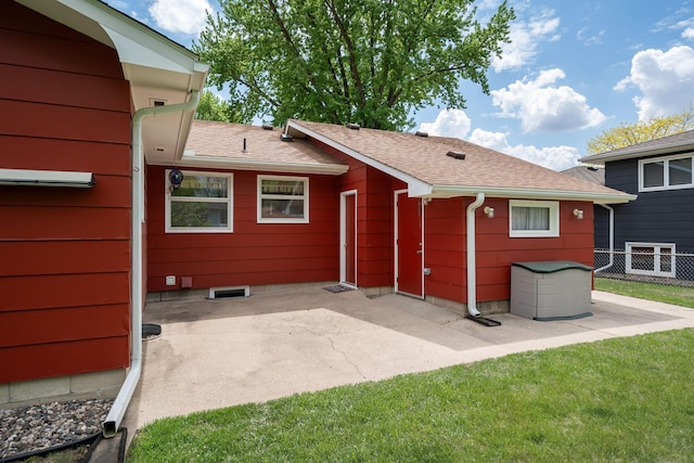 back of property with a patio and a shingled roof