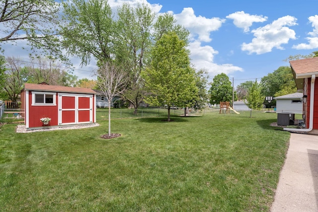 view of yard featuring a shed, a playground, an outbuilding, and cooling unit