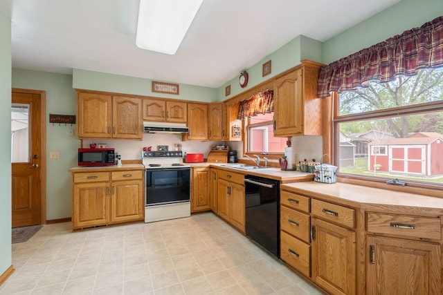 kitchen with electric range oven, black dishwasher, under cabinet range hood, a sink, and healthy amount of natural light
