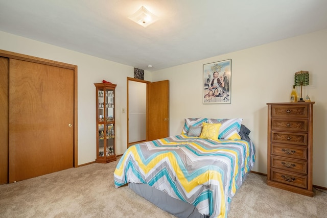 carpeted bedroom featuring a closet and baseboards