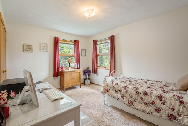 bedroom with light carpet and baseboards