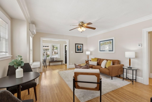 living room featuring a wall unit AC, plenty of natural light, ceiling fan, light wood-style floors, and crown molding