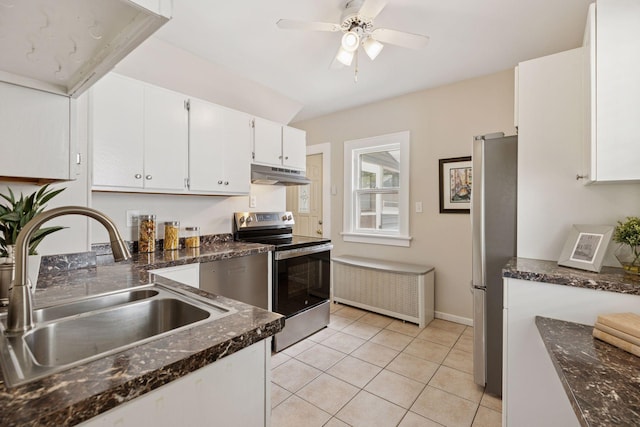 kitchen featuring stainless steel appliances, under cabinet range hood, a sink, white cabinetry, and light tile patterned floors