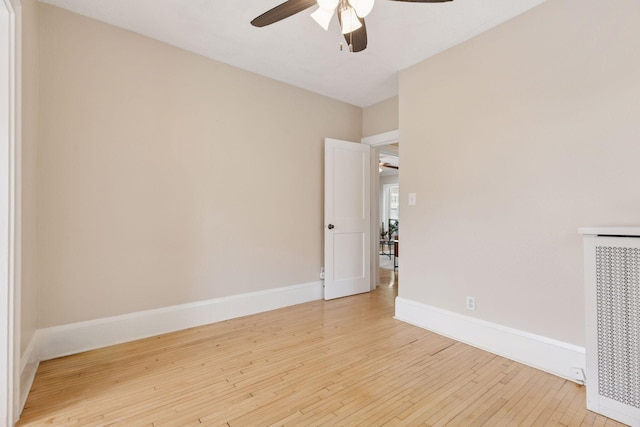 unfurnished room featuring ceiling fan, light wood-style floors, and baseboards