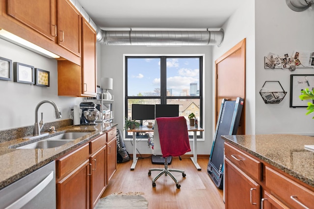 home office with a sink and light wood-style flooring