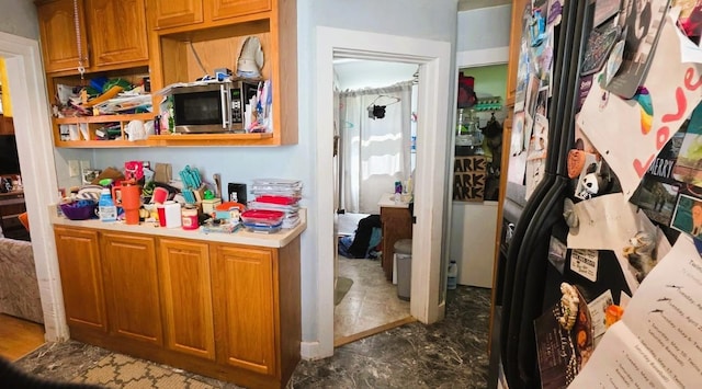 139 2nd St W, Wabasha, MN 55981 - kitchen with stainless steel microwave, light countertops, black fridge, and brown cabinetry