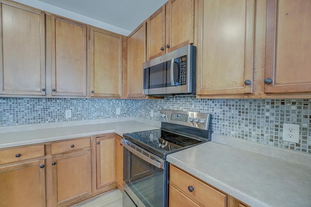 kitchen with appliances with stainless steel finishes, light countertops, and decorative backsplash