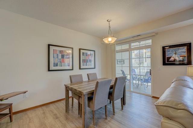 dining area with baseboards and light wood-style flooring