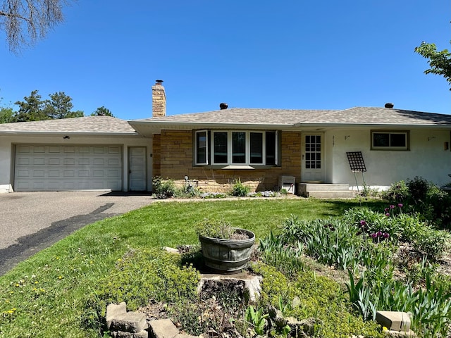 ranch-style house featuring a chimney, an attached garage, driveway, and a front lawn
