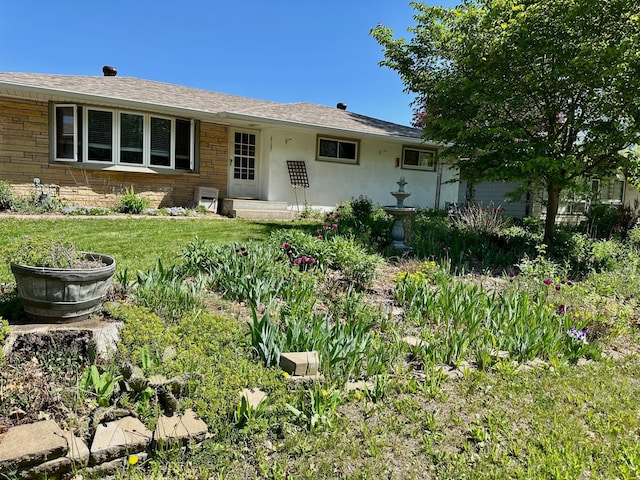 view of front facade with a front yard and roof with shingles