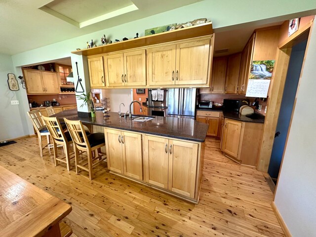 kitchen featuring a sink, light wood-style flooring, and light brown cabinets