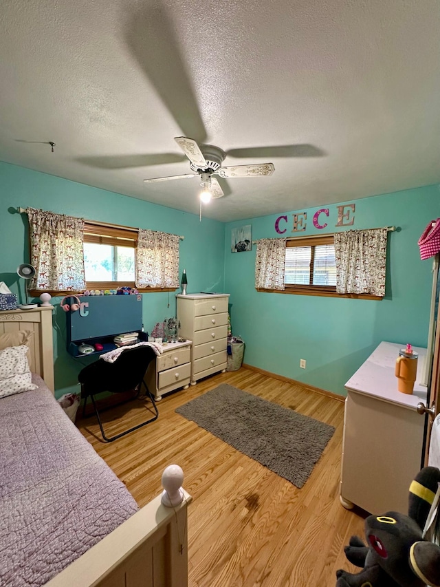 bedroom featuring a textured ceiling, ceiling fan, and light wood-type flooring