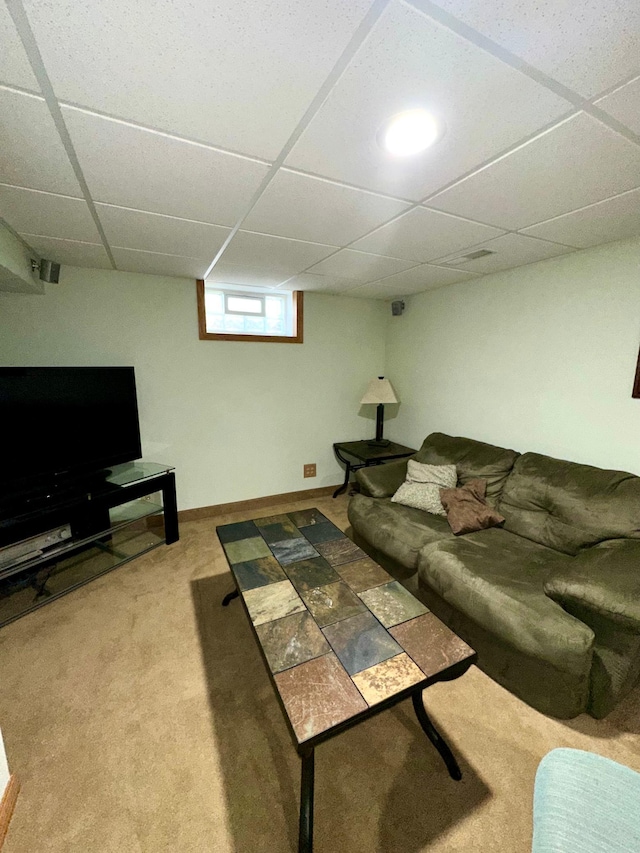 living room featuring carpet, a paneled ceiling, and baseboards