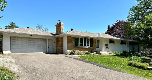 2127 S Ave E, North Saint Paul, MN 55109 - ranch-style home with a garage, a chimney, asphalt driveway, and a front yard