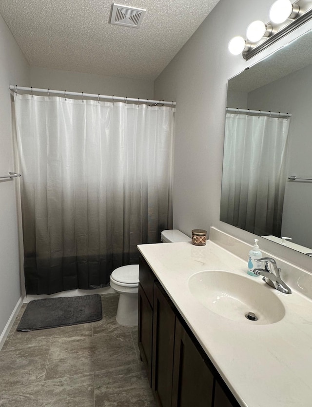 full bathroom featuring a textured ceiling, vanity, and toilet