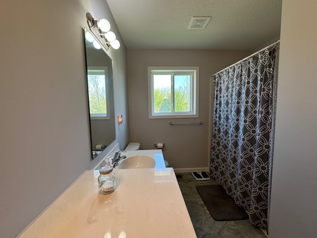 full bathroom featuring a textured ceiling, vanity, toilet, curtained shower, and baseboards