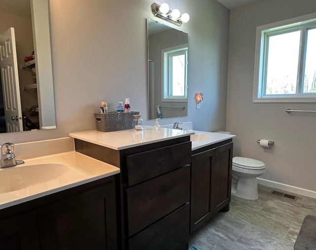 bathroom with vanity, toilet, and baseboards