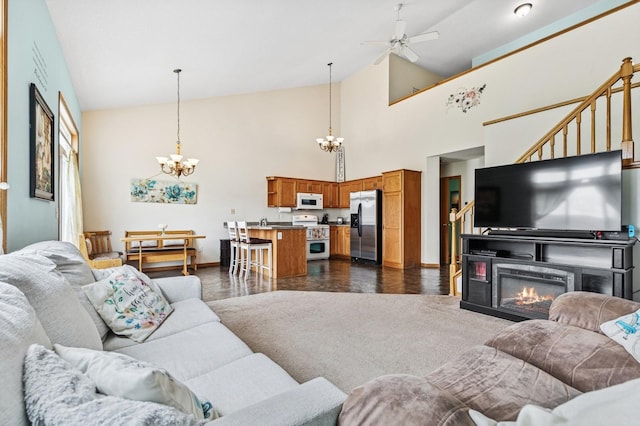 2141 Cleveland Ln S, Cambridge, MN 55008 - living area featuring a chandelier, a ceiling fan, high vaulted ceiling, stairs, and a glass covered fireplace