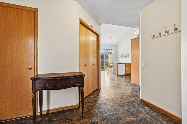2141 Cleveland Ln S, Cambridge, MN 55008 - corridor featuring a chandelier, stone finish flooring, and lofted ceiling