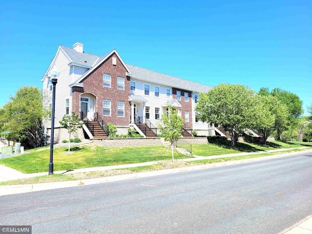 11305 Fergus St NE Unit D, Blaine, MN 55449 - townhome / multi-family property featuring a chimney, a front yard, and brick siding