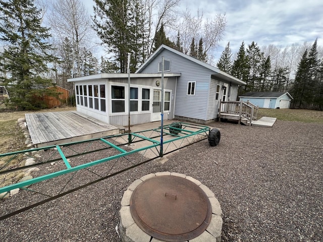 11749 Side Dr, Fine Lakes Twp, MN 55798 - back of house featuring a wooden deck, an outdoor structure, and a storage unit