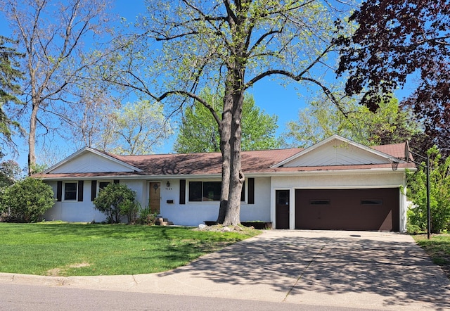 ranch-style house with concrete driveway, a front yard, an attached garage, and stucco siding