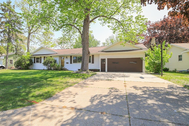 ranch-style home with a garage, concrete driveway, and a front yard