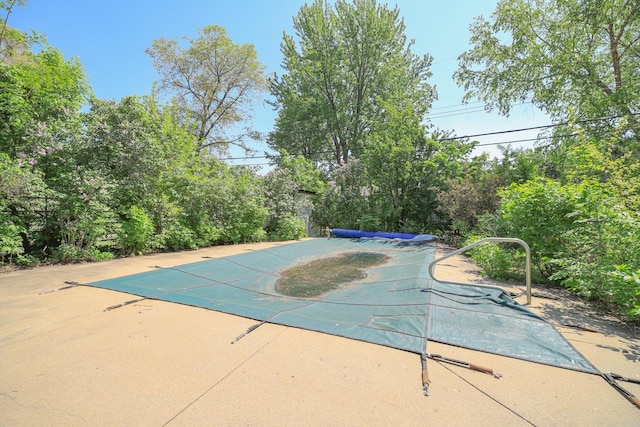 view of swimming pool featuring a covered pool and a patio area