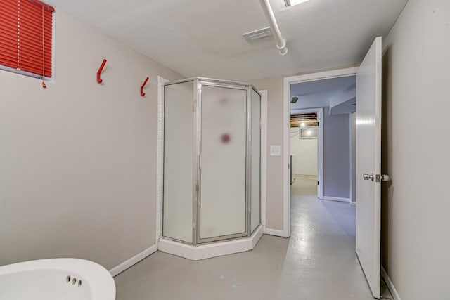 full bathroom featuring a stall shower, finished concrete flooring, and baseboards