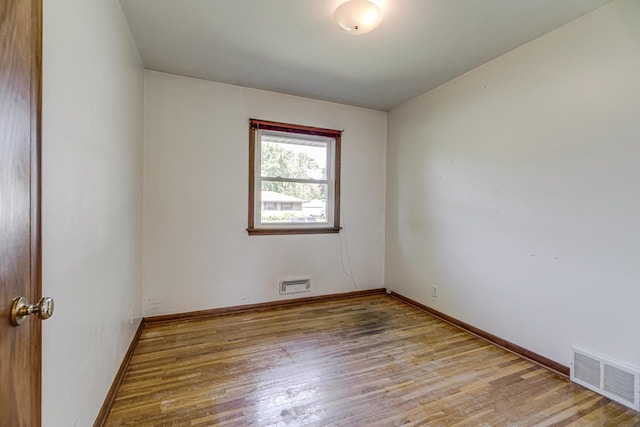 spare room with wood finished floors and baseboards