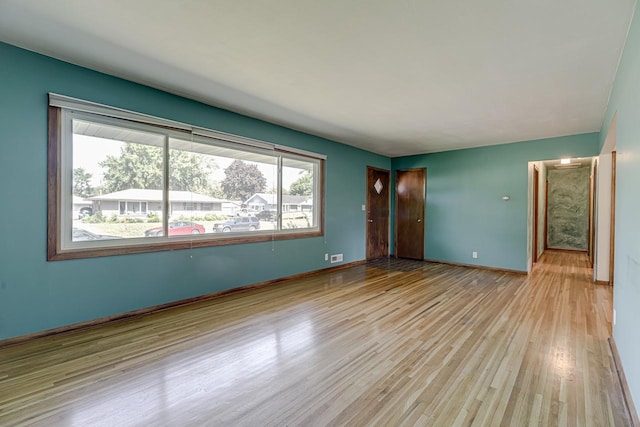 unfurnished room featuring light wood finished floors and baseboards