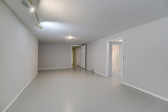 empty room featuring finished concrete floors and baseboards