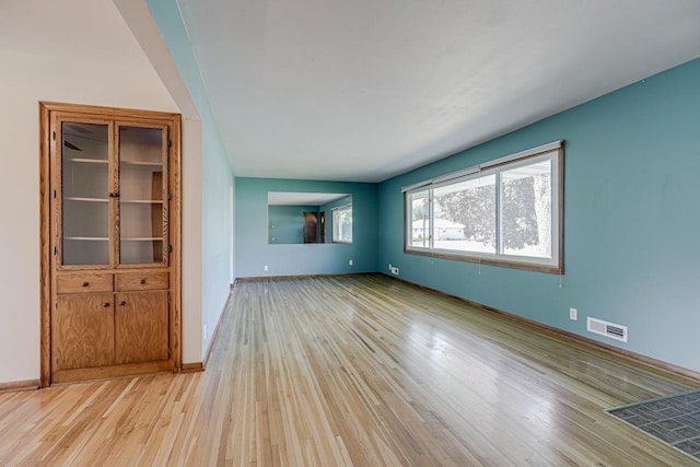 spare room featuring light wood-style floors and baseboards