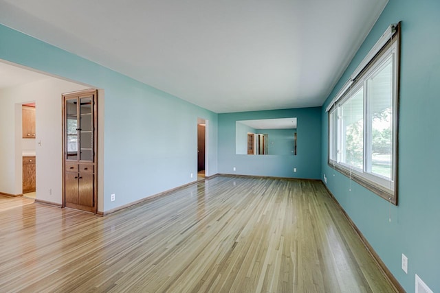 unfurnished room with light wood-style floors and baseboards