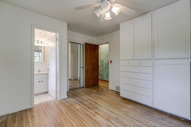 unfurnished bedroom featuring light wood-type flooring, ensuite bathroom, baseboards, and ceiling fan