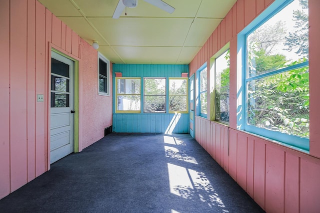 unfurnished sunroom with a ceiling fan and healthy amount of natural light