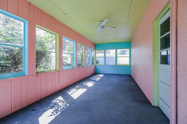 unfurnished sunroom featuring ceiling fan