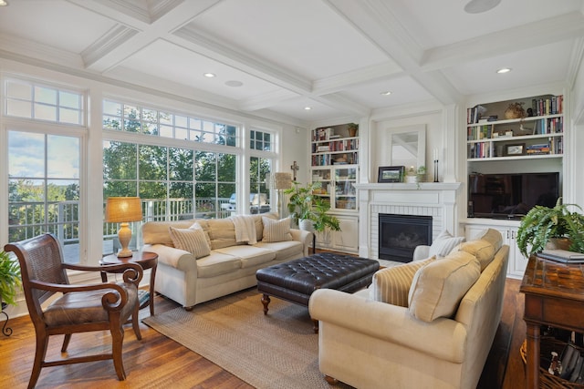 living room featuring wood finished floors, beam ceiling, coffered ceiling, a fireplace, and built in features