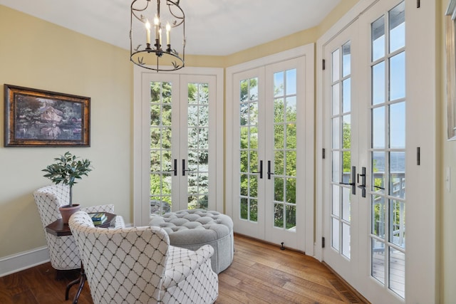 entryway with french doors, a chandelier, wood finished floors, and baseboards