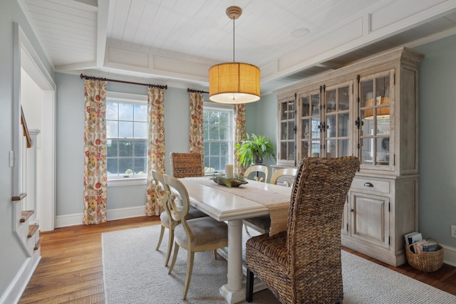 dining room with light wood-style flooring, wooden ceiling, and baseboards