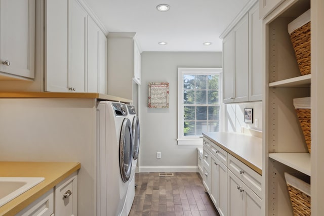 clothes washing area featuring cabinet space, baseboards, washer and clothes dryer, and recessed lighting