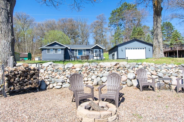 view of yard with a fire pit, an outbuilding, and a detached garage