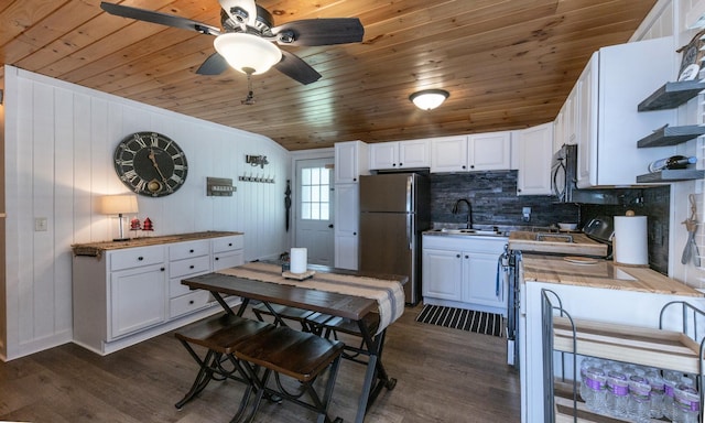kitchen with freestanding refrigerator, wood ceiling, a sink, dark wood-style floors, and white cabinets