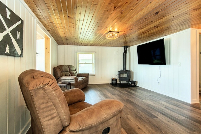 living area with wood ceiling, a wood stove, dark wood finished floors, baseboards, and wood walls
