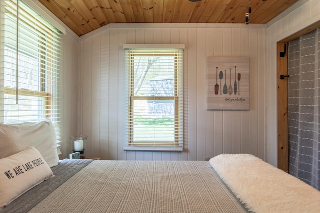bedroom with multiple windows, wood walls, and wood ceiling