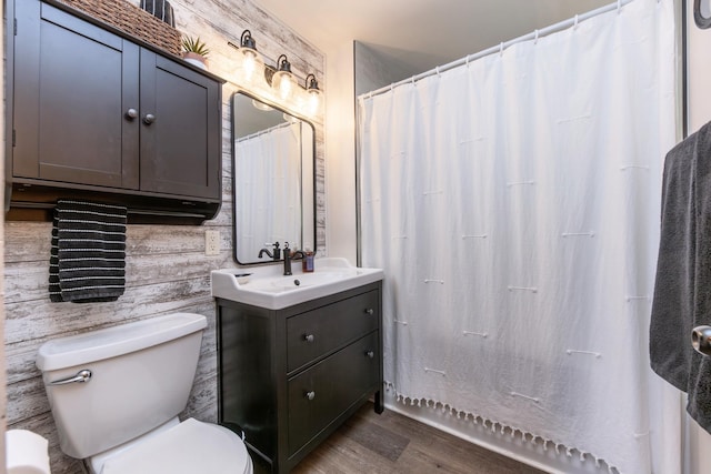 full bathroom with wood finished floors, toilet, and vanity