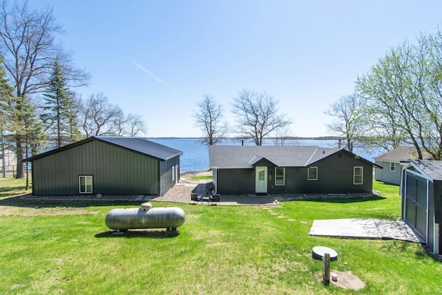 back of house featuring a yard, an outdoor structure, and a patio area