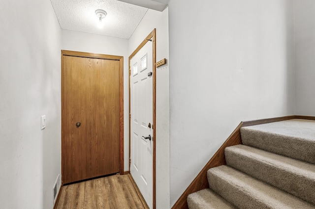 2478 Cobble Hill Alcove Unit C, Woodbury, MN 55125 - foyer featuring a textured ceiling, stairs, baseboards, and wood finished floors