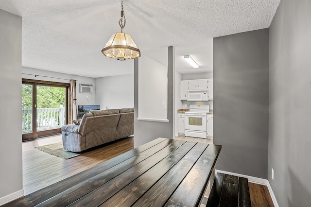 2478 Cobble Hill Alcove Unit C, Woodbury, MN 55125 - dining area with a textured ceiling, a chandelier, wood finished floors, an AC wall unit, and baseboards