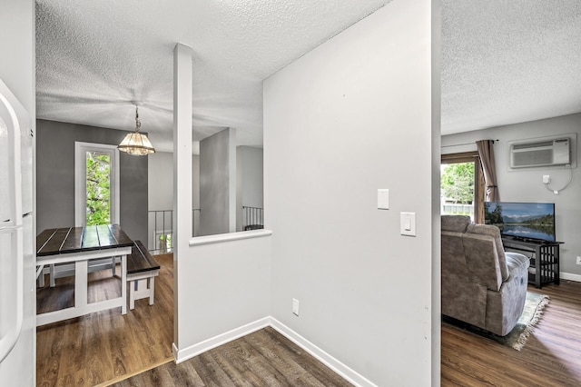 2478 Cobble Hill Alcove Unit C, Woodbury, MN 55125 - hallway featuring a wall mounted AC, a textured ceiling, dark wood-style floors, and baseboards
